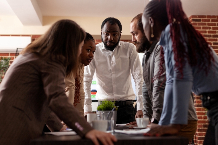 Multi-ethnic entrepreneurs stand up analyzing financial graph